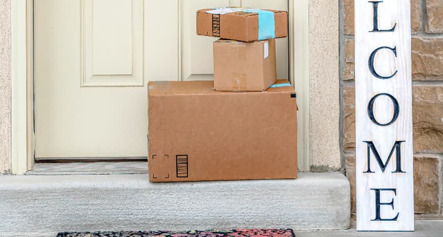 Packages on the doorstep of a home with a welcome sign in Provo